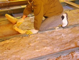A construction worker thermally insulating a house attic
